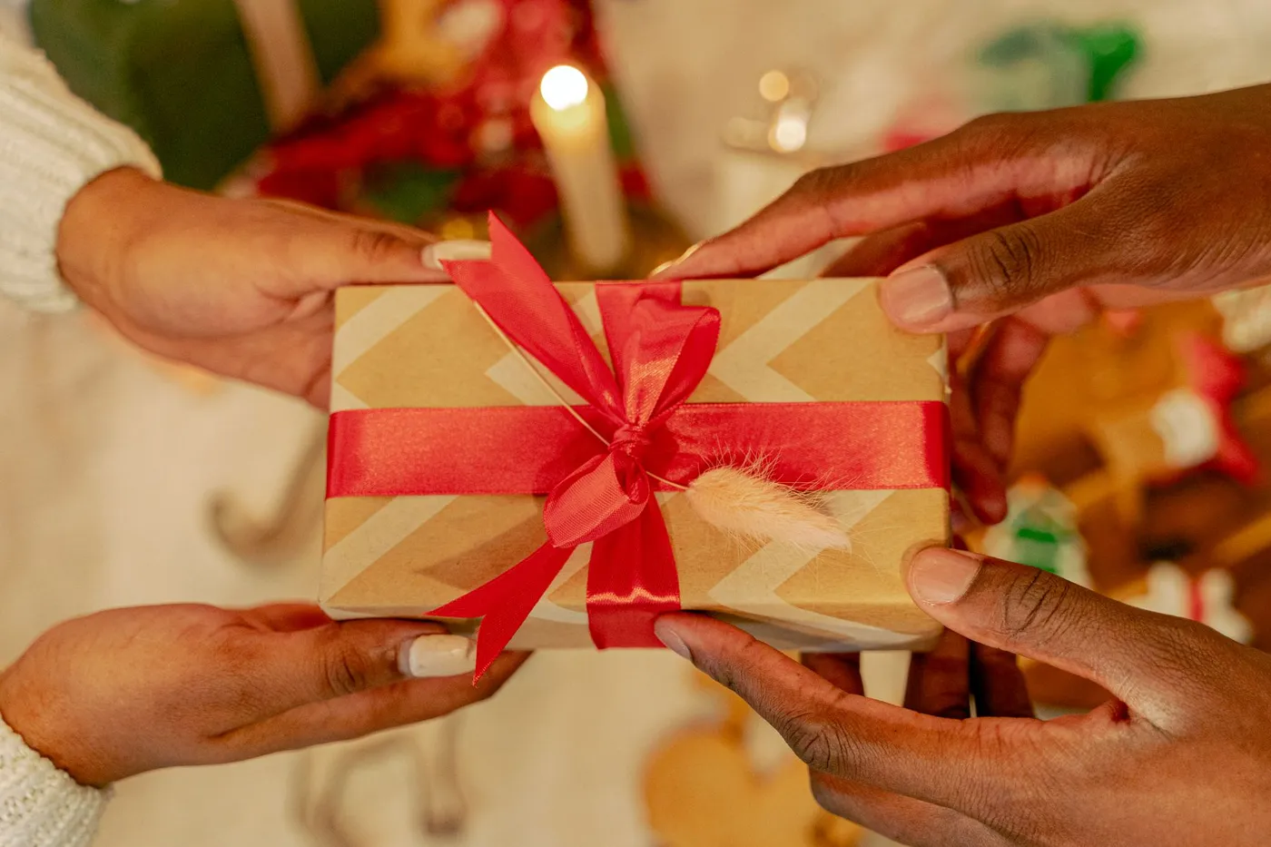 Dos personas intercambiando un pequeño regalo junto a la luz de una vela