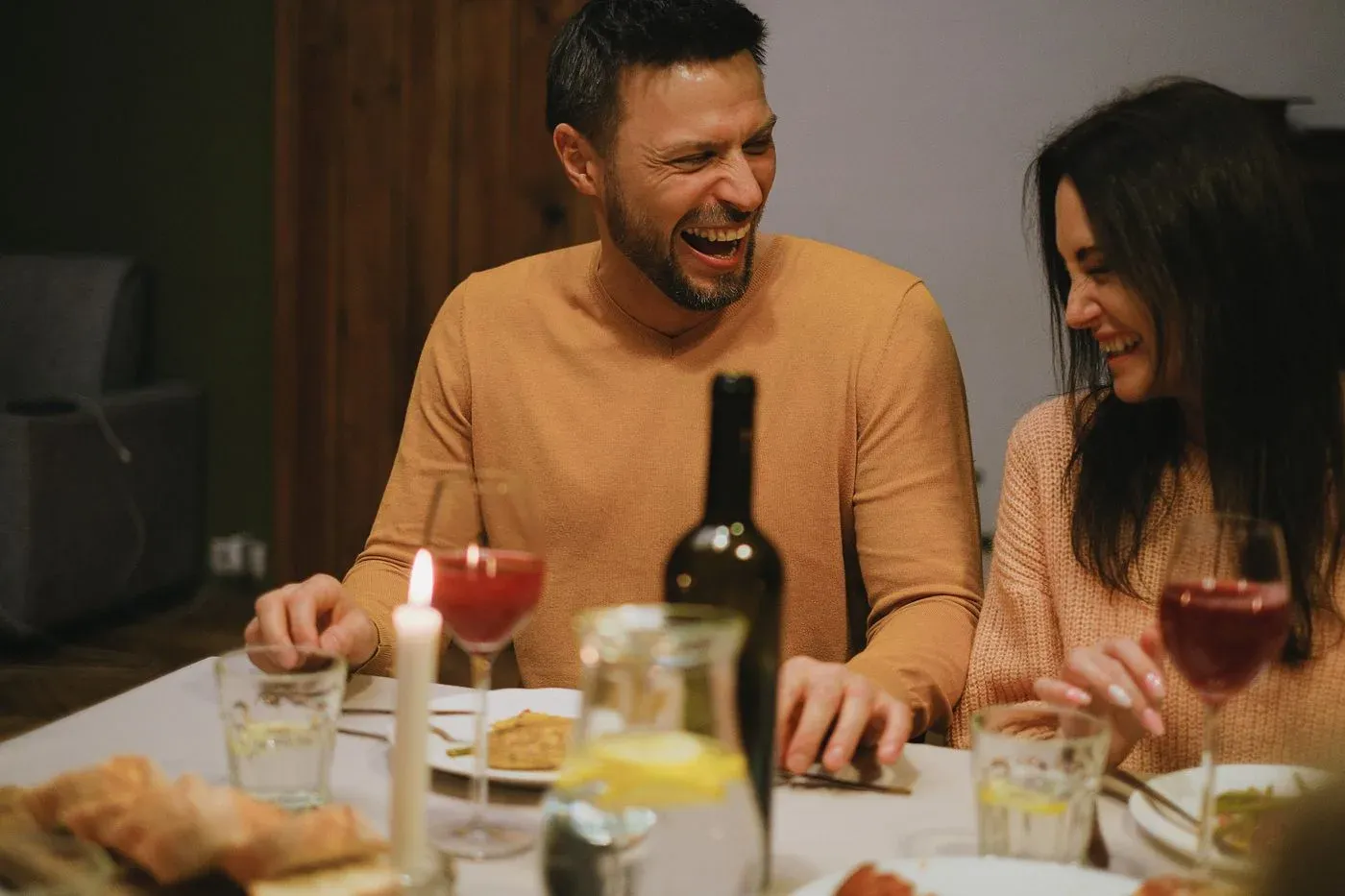 Pareja riendo y abrazándose con complicidad