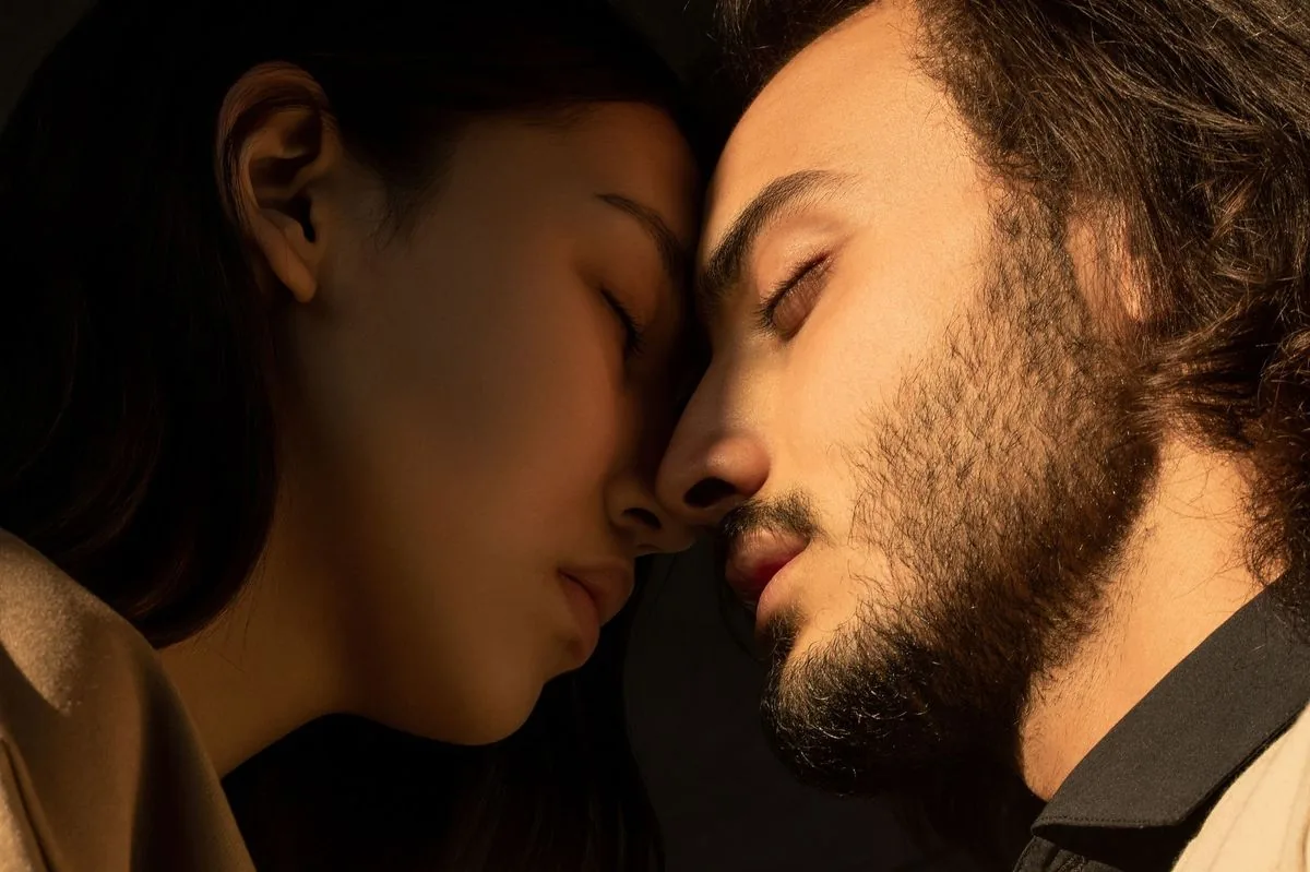 Pareja frente con frente y con los ojos cerrados, a punto de besarse