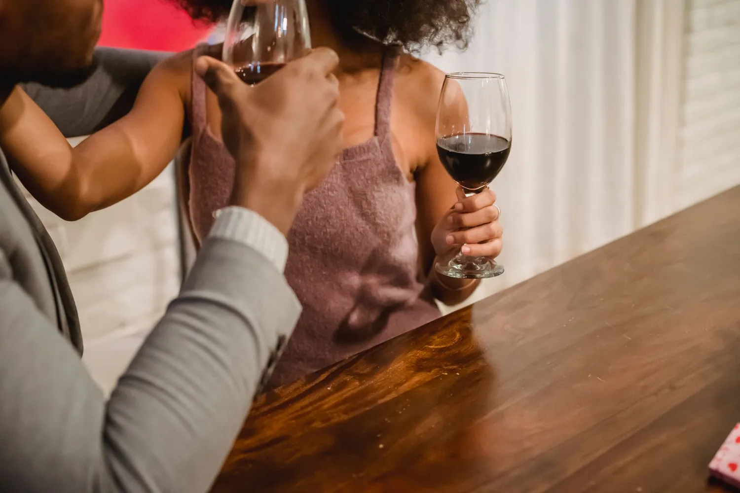 Pareja compartiendo una copa de vino en luz cálida