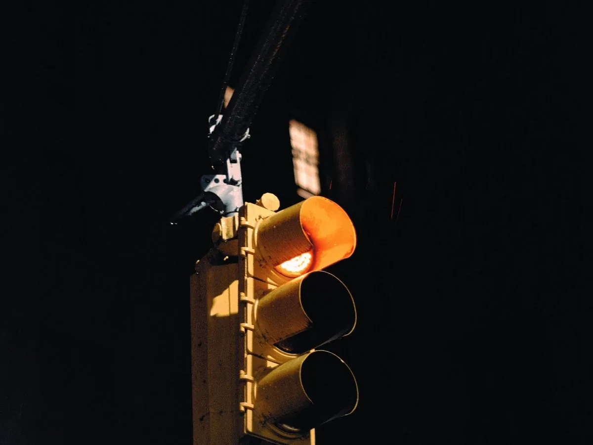Semáforo con la luz ámbar encendida en medio de la noche