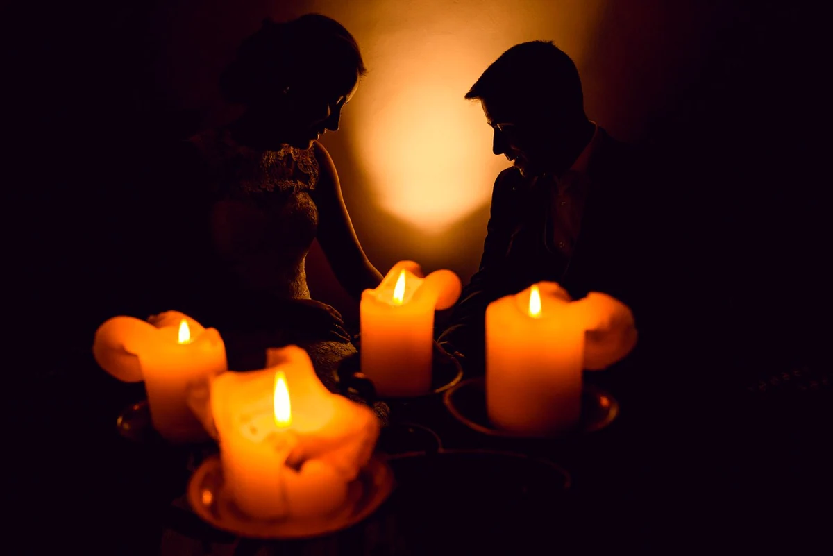 Dos personas frente a frente a la luz de las velas