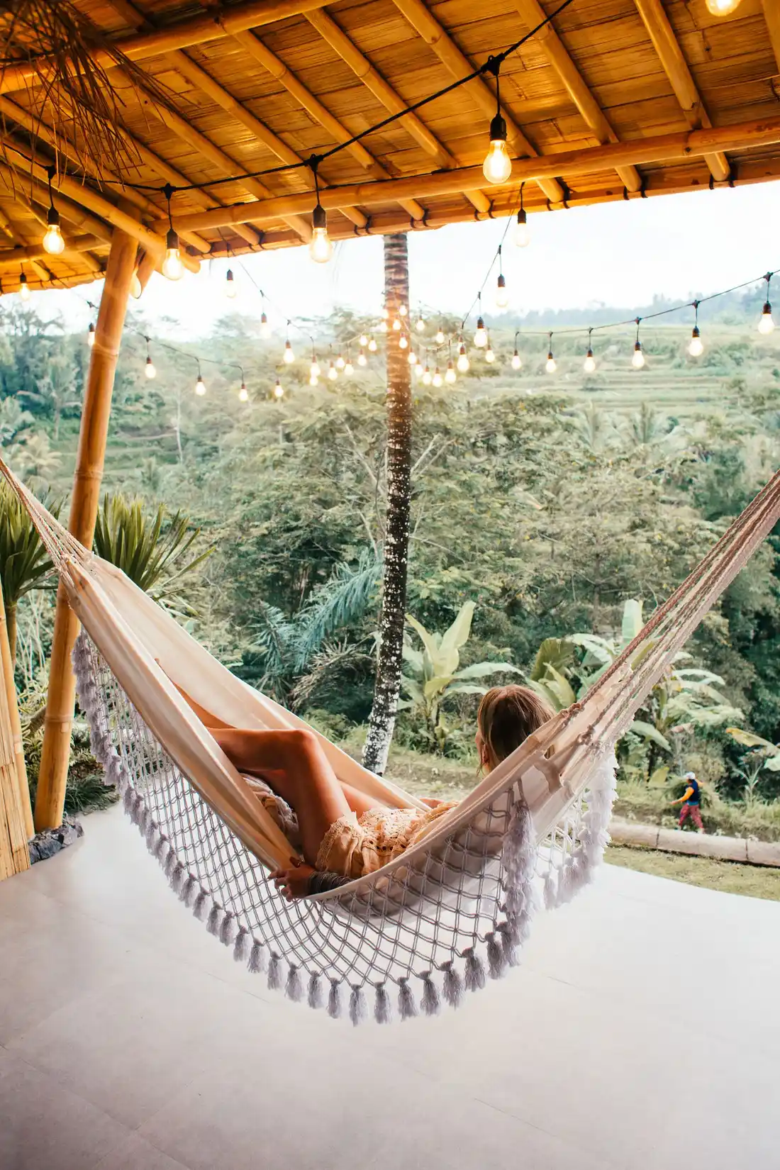 Mujer descansando en una hamaca bajo luces cálidas