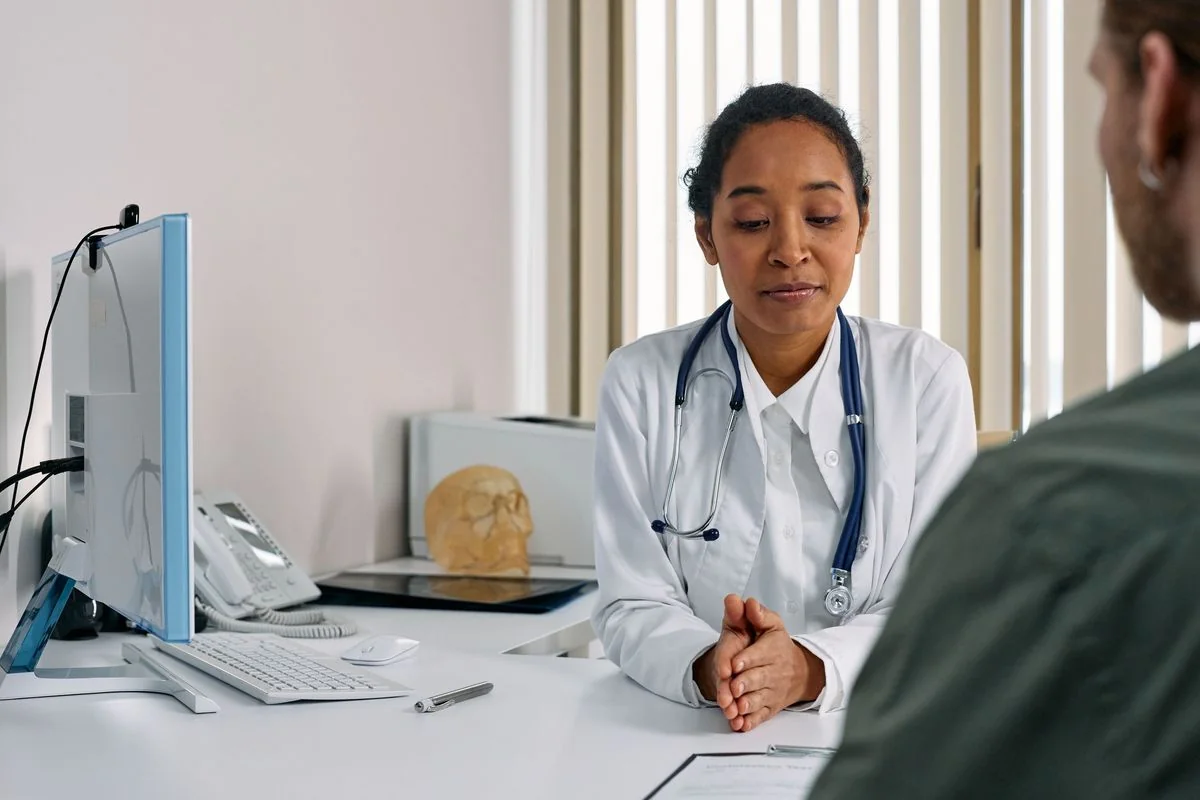 Doctora escuchando con atención a su paciente en el consultorio