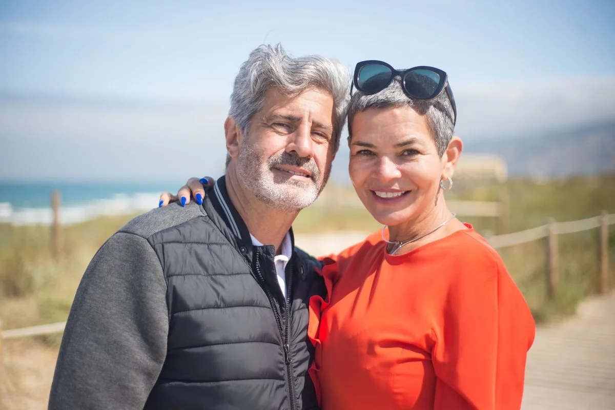 Pareja de unos cincuenta años, abrazada y sonriente al aire libre